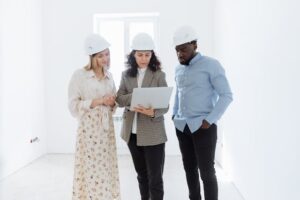 Pessoas usando capacetes de proteção e olhando para um documento