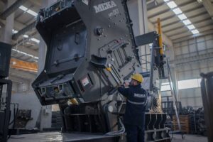 Homem mexendo uma máquina em seu trabalho