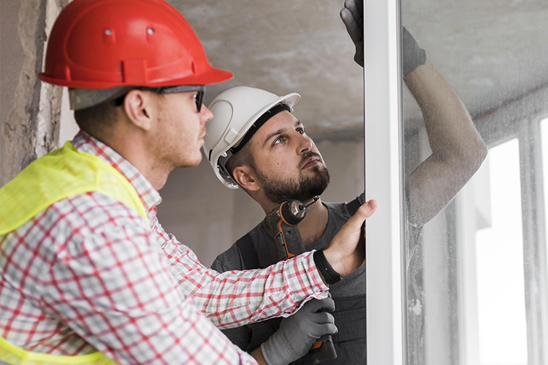 Homens em uma construção utilizando EPIs