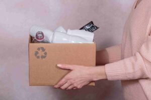 mulher segurando caixa de lixo