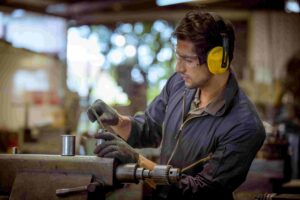 Trabalhador usando protetores auriculares