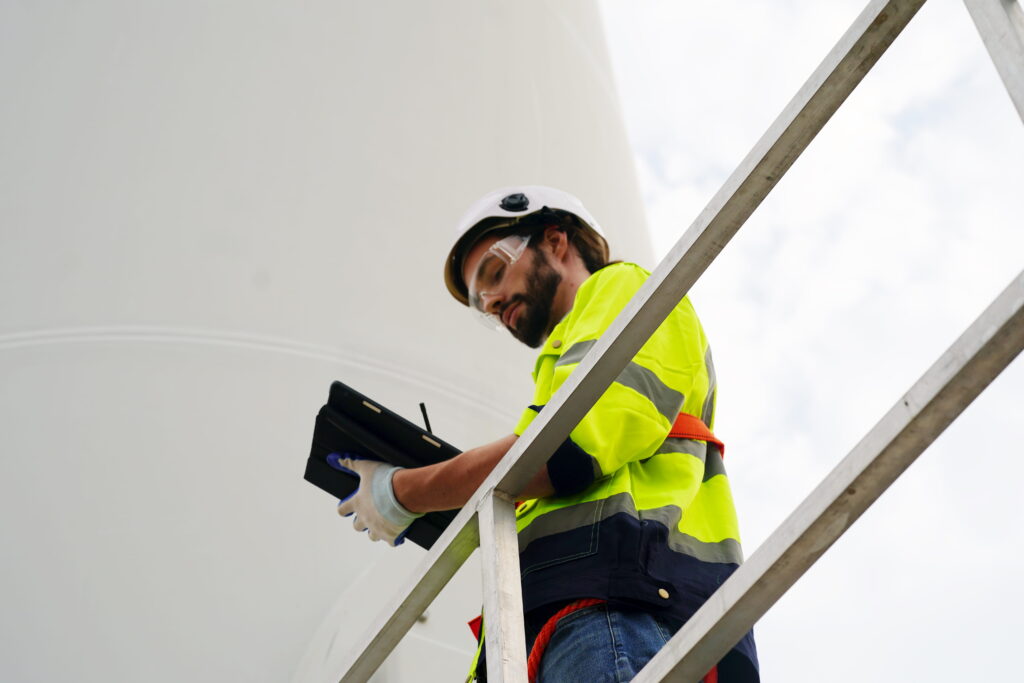 Engenheiro trabalhando em parque e&oacute;lico de energia renov&aacute;vel alternativa - Conceito de ind&uacute;stria de energia sustent&aacute;vel