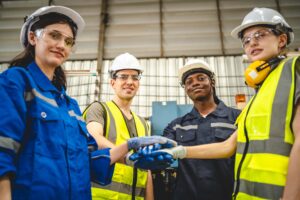 Testando uma nova ferramenta de inovação em automação para a indústria inteligente. Engenheiros robóticos profissionais especializados em manutenção e controle de braços robóticos em armazéns de fábrica trabalham em equipe.