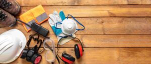 Saúde e segurança no trabalho. Equipamentos de proteção individual para trabalhadores da indústria e da construção civil. Equipamentos de proteção sobre fundo de madeira, banner, espaço para texto.