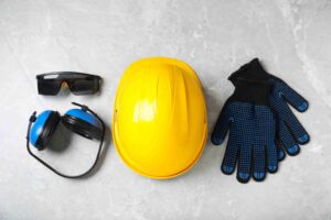Diversos equipamentos de segurança sobre mesa de mármore cinza claro, dispostos horizontalmente.