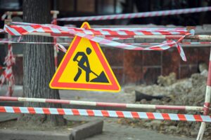 Sinal de advertência de obras rodoviárias e barreira de segurança na rua da cidade durante trabalhos de reparo de manutenção